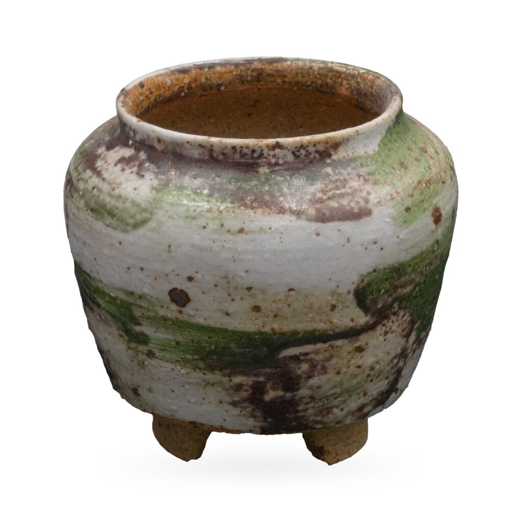 Rounded footed jar pot in creamy white glaze with moss green washes and purple-brown speckles