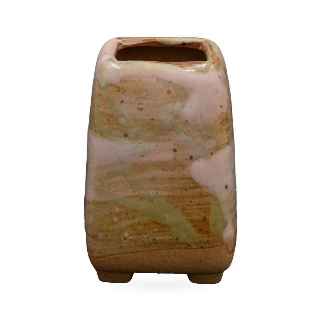 Tall tapered square pot with creamy pink drip glaze over rust-orange and green streaks, on small feet