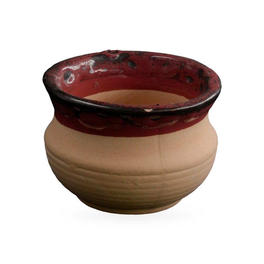 Small sand-coloured ribbed clay bowl pot with a glossy red and black glazed rim