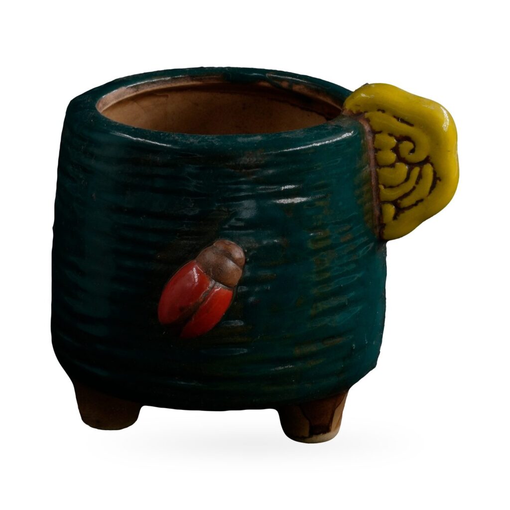 Dark green combed-texture footed pot with a yellow cloud-swirl tab and red ladybird