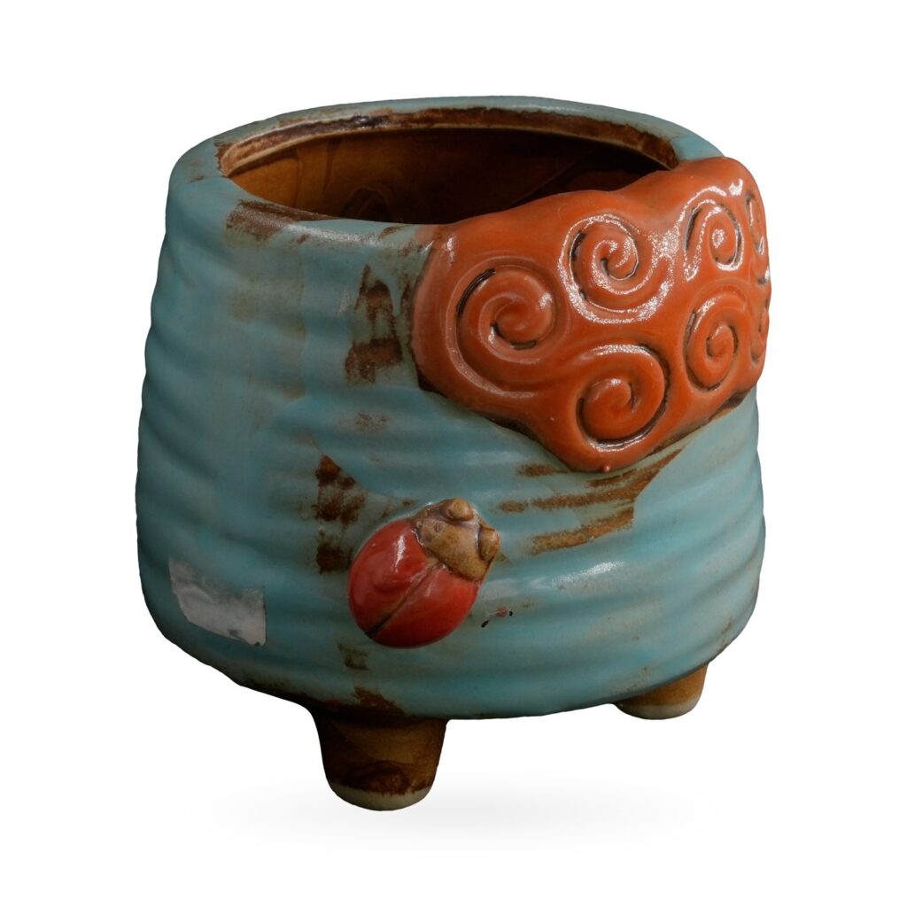 Light-blue ribbed footed pot with an orange cloud-swirl panel and red ladybird
