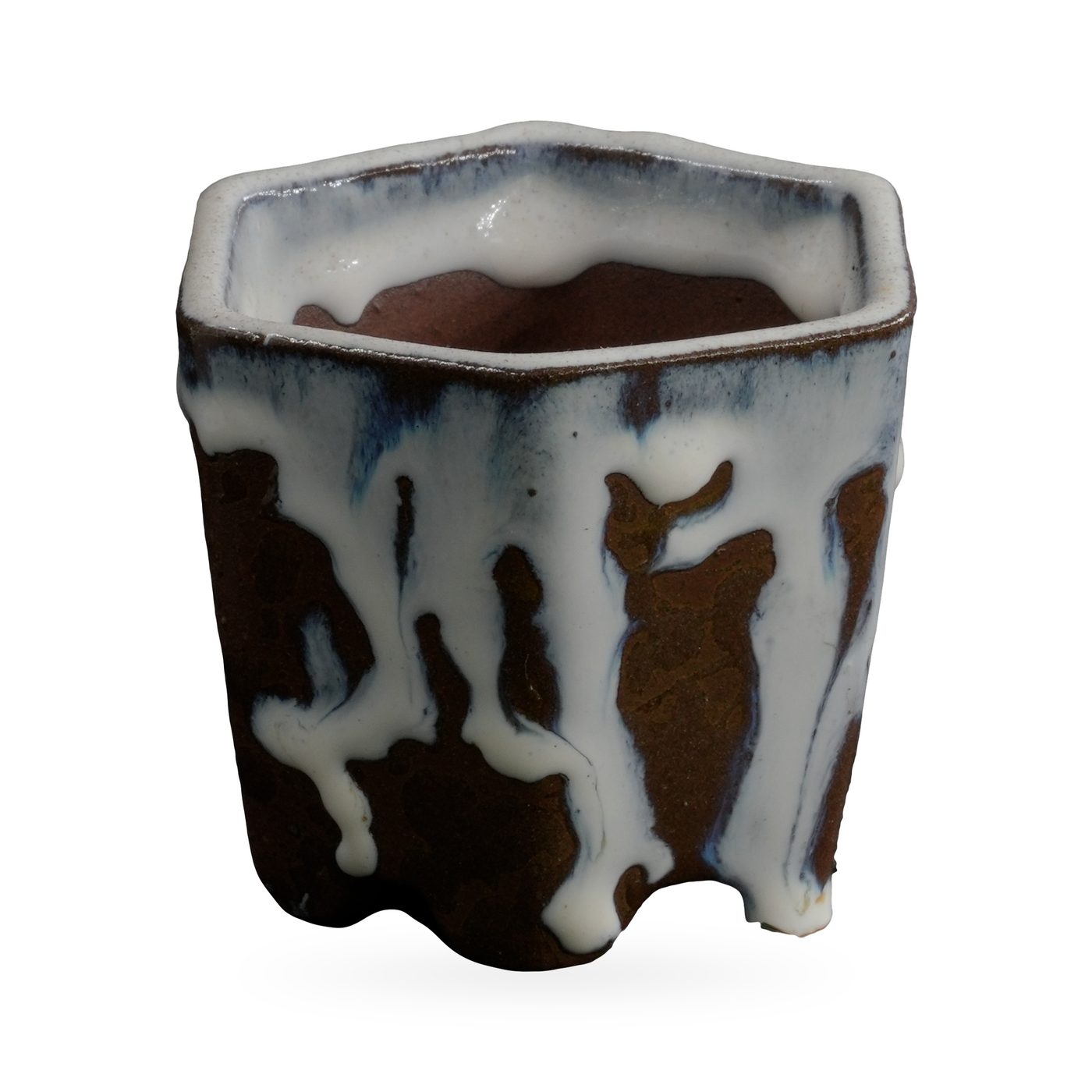 Hexagonal dark brown textured pot with thick white glaze dripping from the rim