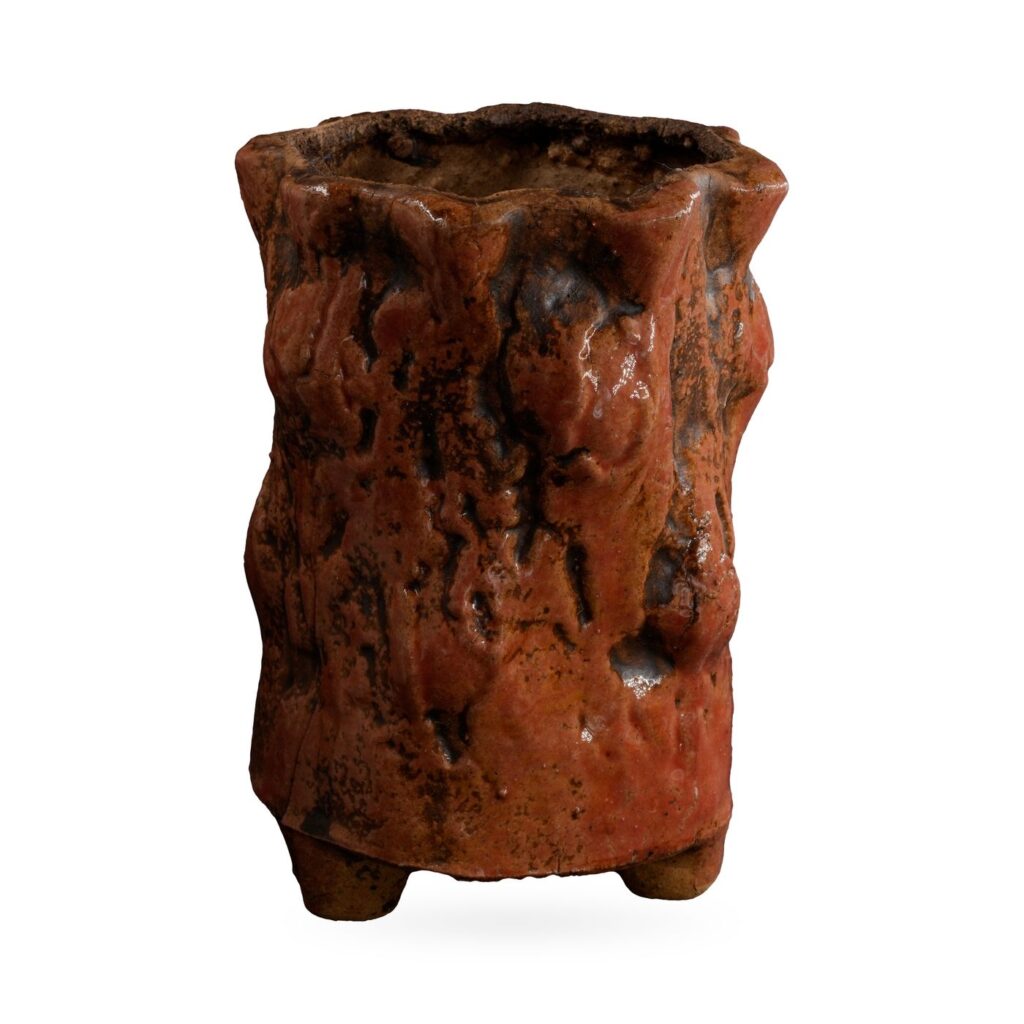 Tall rust-red bark-textured footed pot with dark brown tones and a wavy rim
