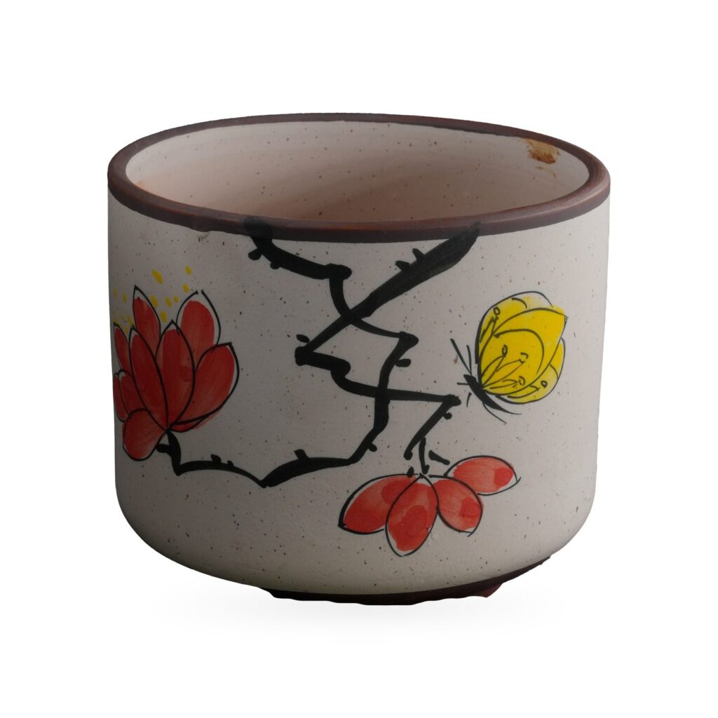 Speckled cream cylinder pot painted with red blossoms, a black branch and a yellow butterfly
