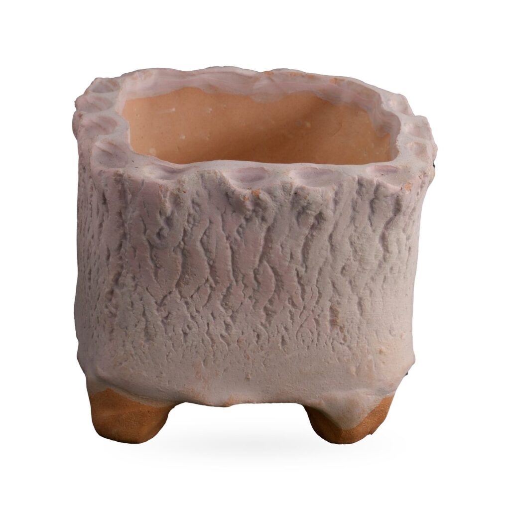 Pink-white square footed pot with bark-like texture, scalloped rim and terracotta-coloured feet