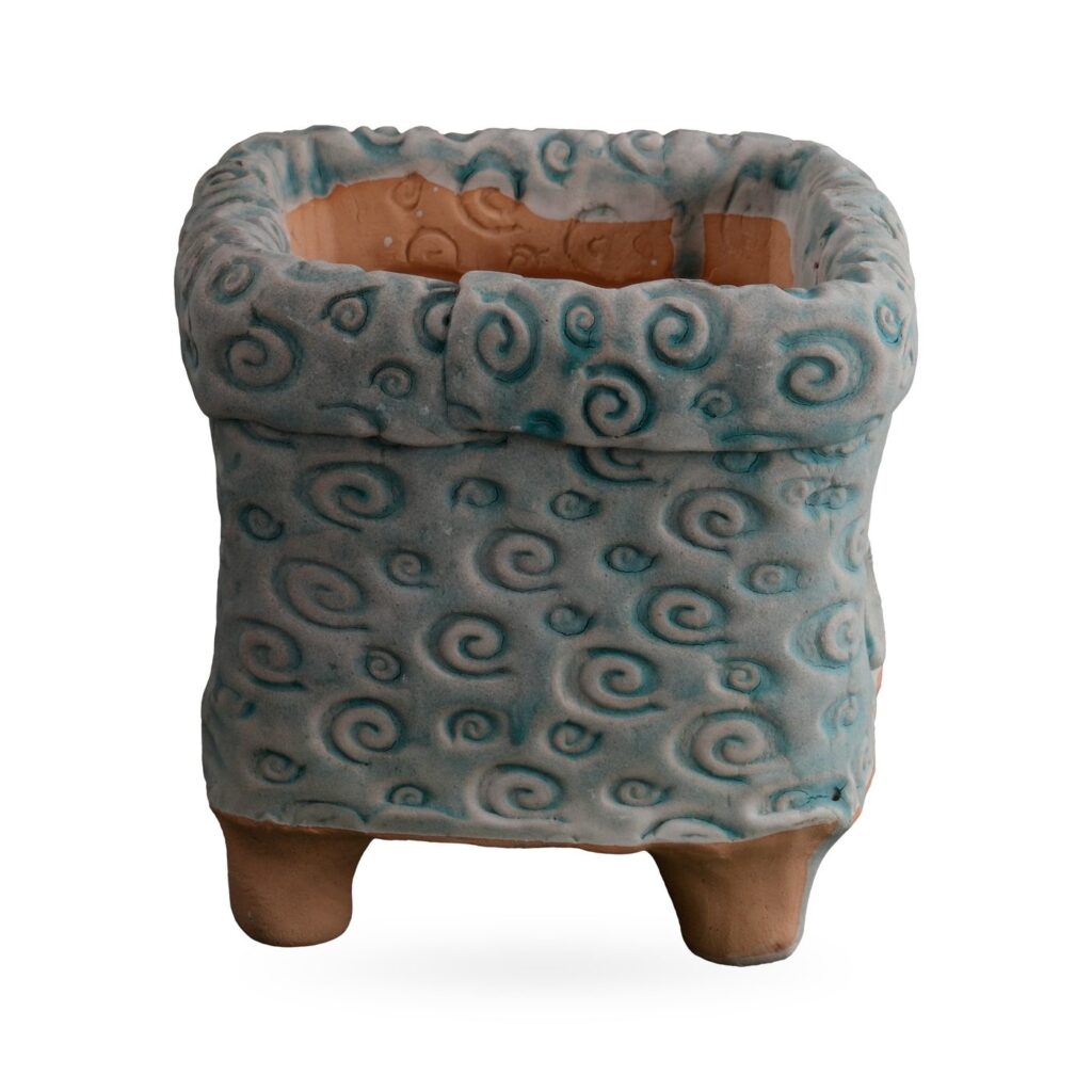 Square footed pot covered in raised swirls with grey-blue and teal glaze and a folded collar rim