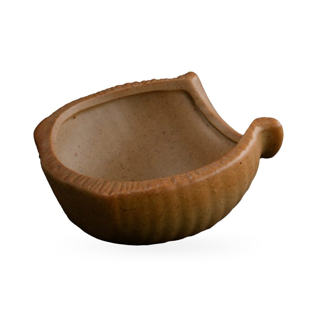 Shallow boat-shaped ribbed succulent pot in speckled sand beige with a curled handle at one end