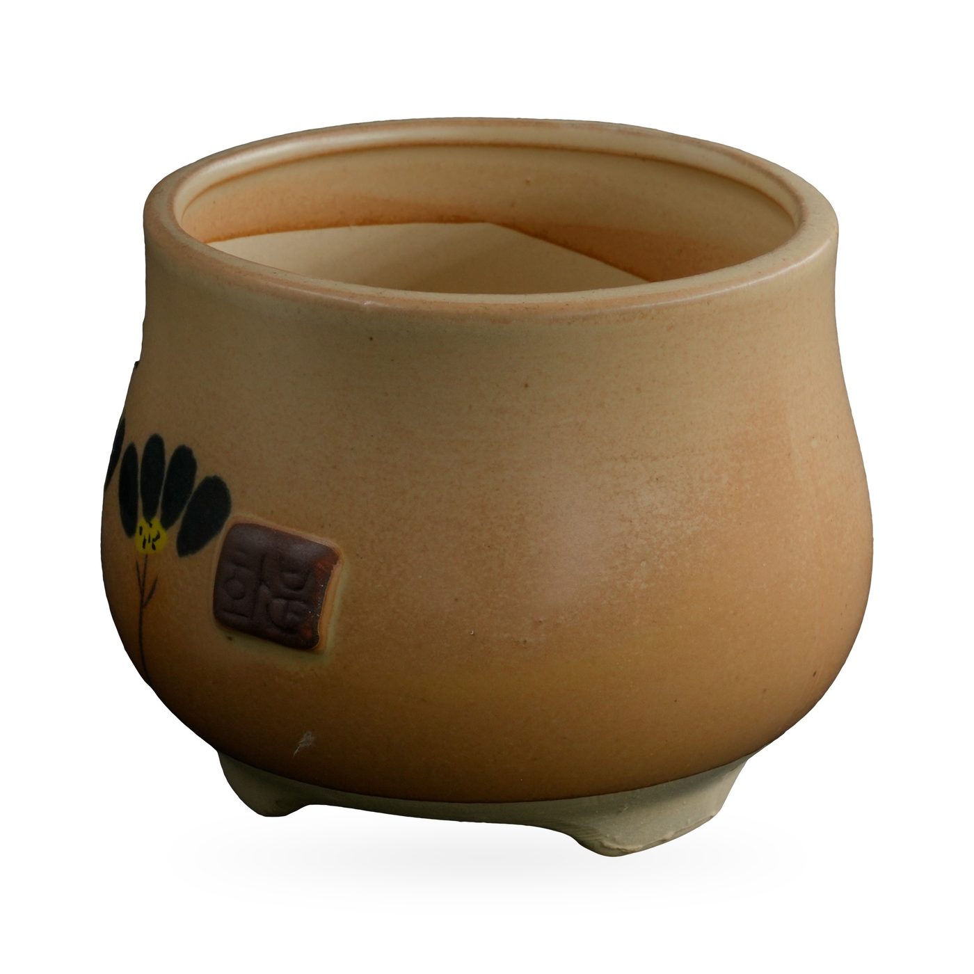 Ochre-yellow footed pot with painted black flowers and a small brown seal-style plaque – view 2