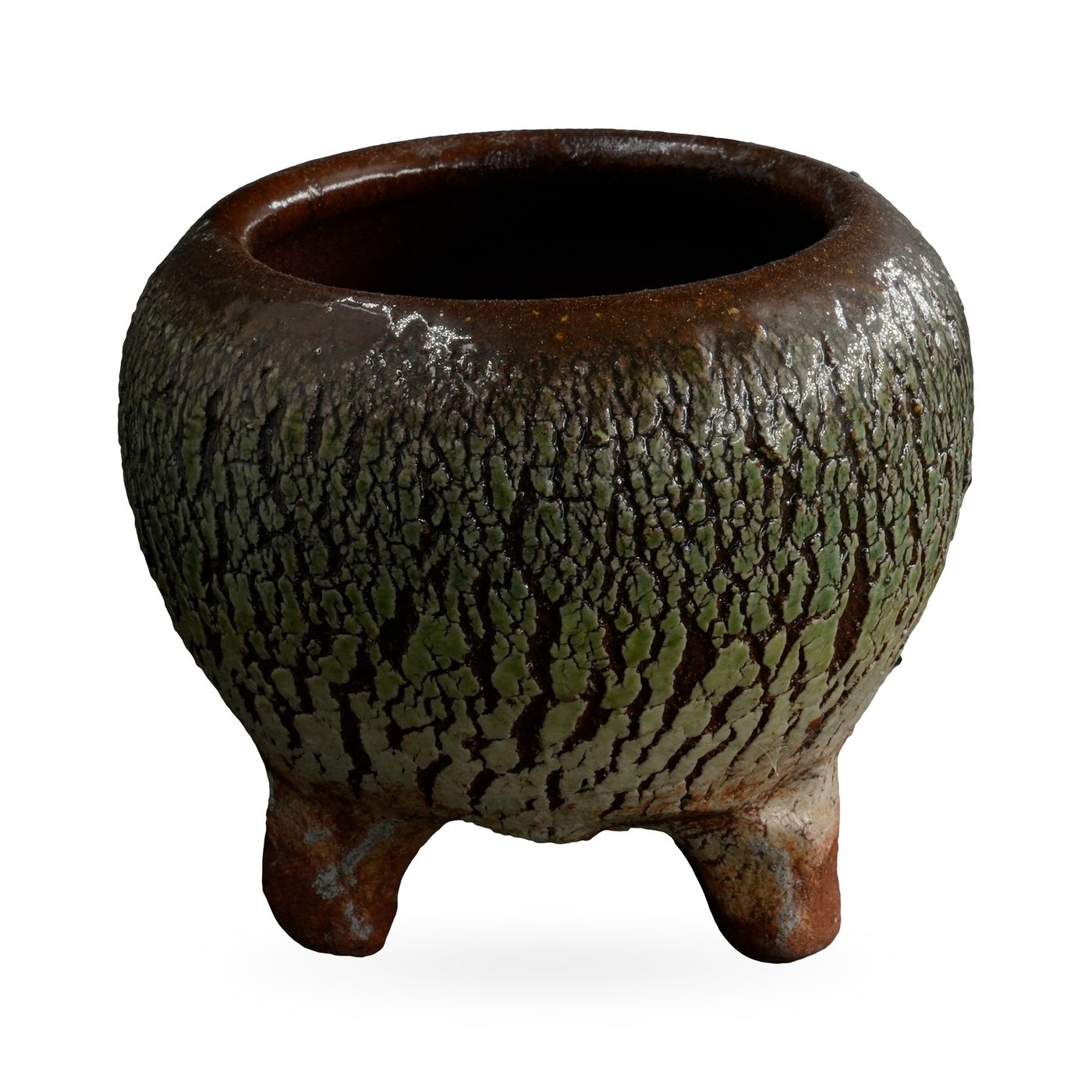 Round pot with a bark-like moss green crackle texture over dark brown, on short terracotta-toned feet