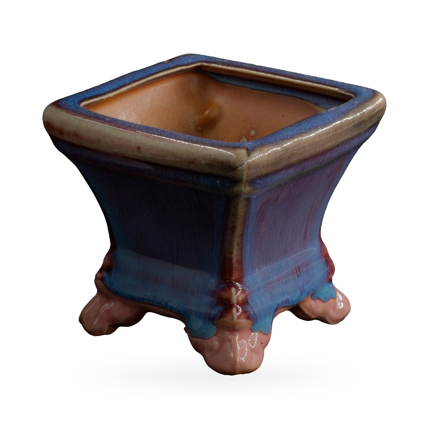 Square pot in glossy blue glaze streaked with purple, with a beige-edged rim, on glossy pink cloud-shaped feet – view 2