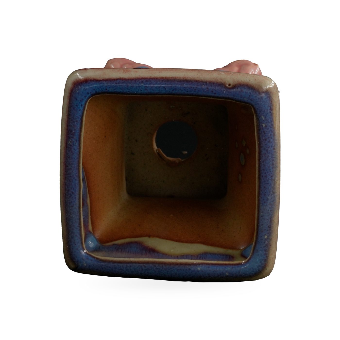 Square pot in glossy blue glaze streaked with purple, with a beige-edged rim, on glossy pink cloud-shaped feet – view 3
