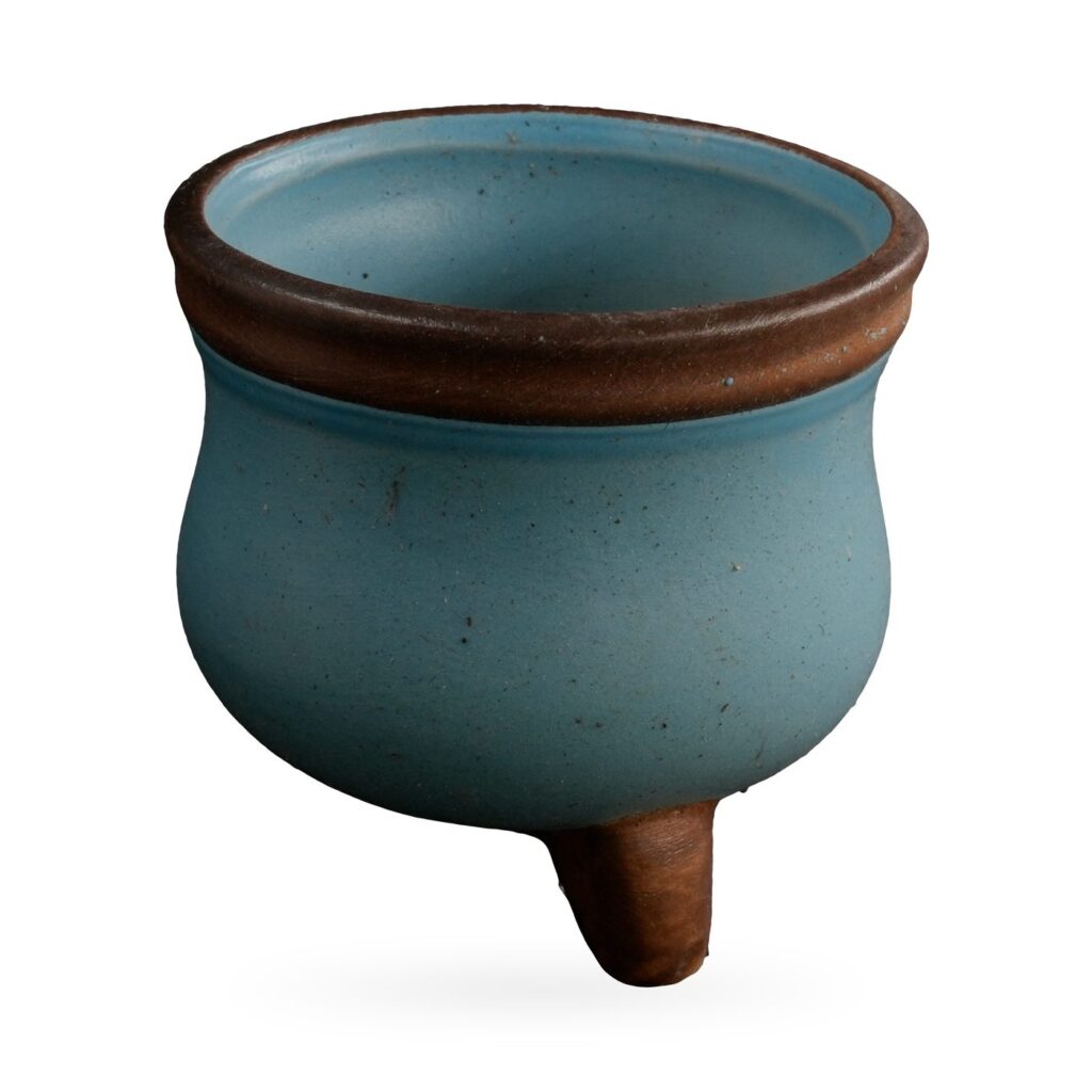 Small matte duck-egg blue cauldron-shaped succulent pot with brown rim on short brown feet