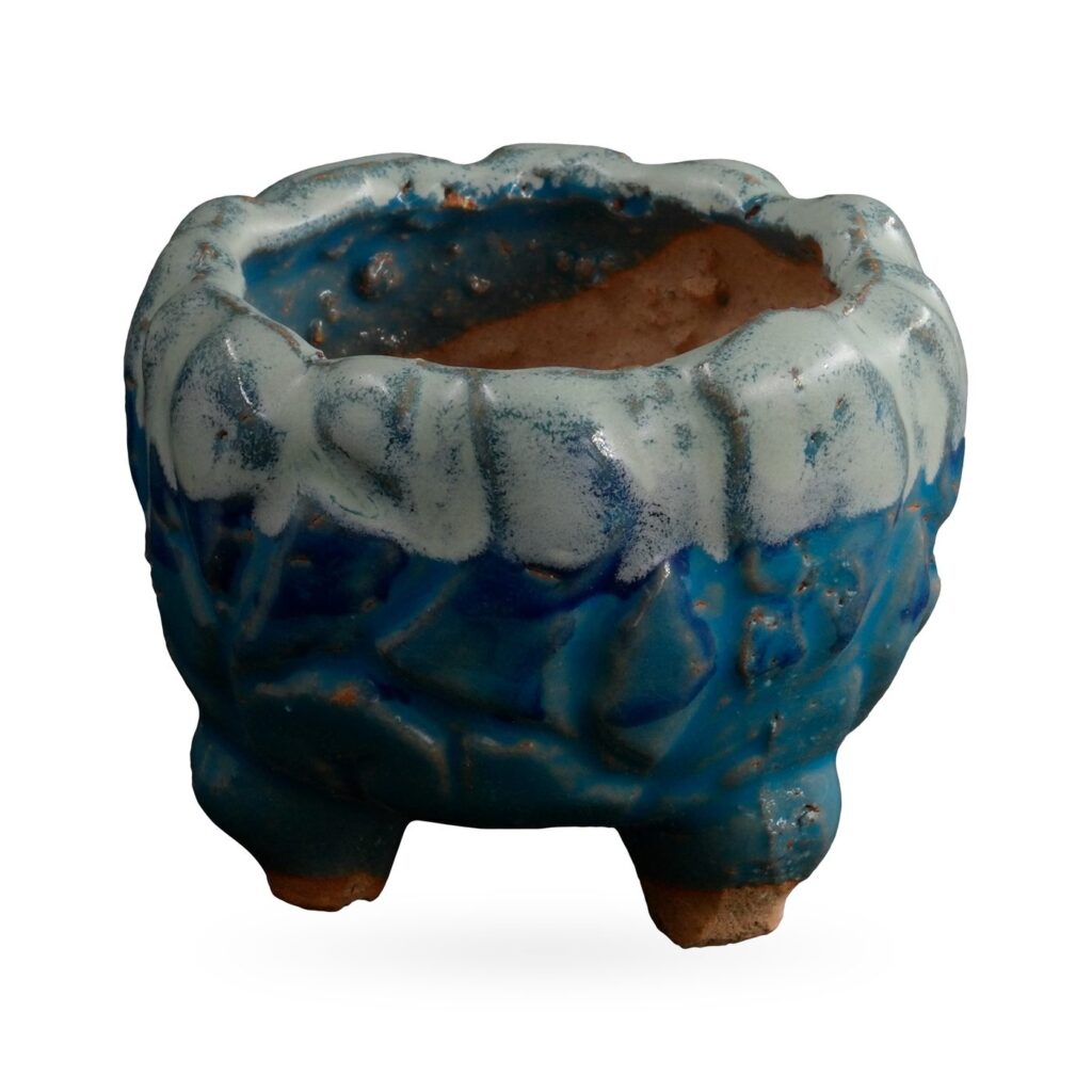 Footed textured pot in glossy blue with a pale white drip glaze around the rim