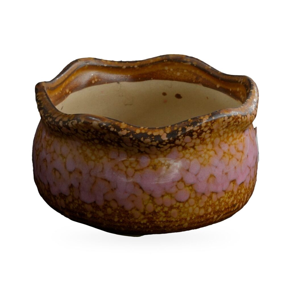 Low wavy-rim pot with glossy pink speckles over amber and brown glaze