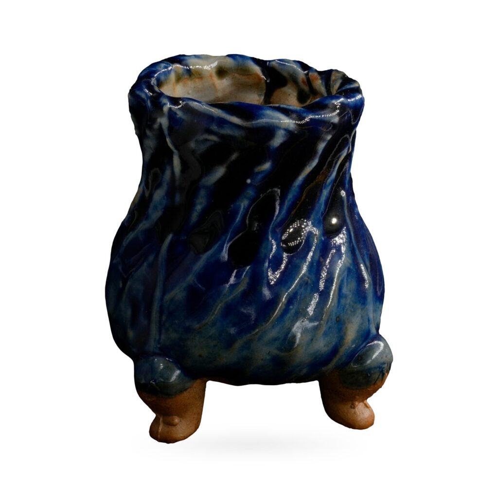 Tall footed pot with a twisted ridged body in glossy cobalt blue glaze with pale streaks