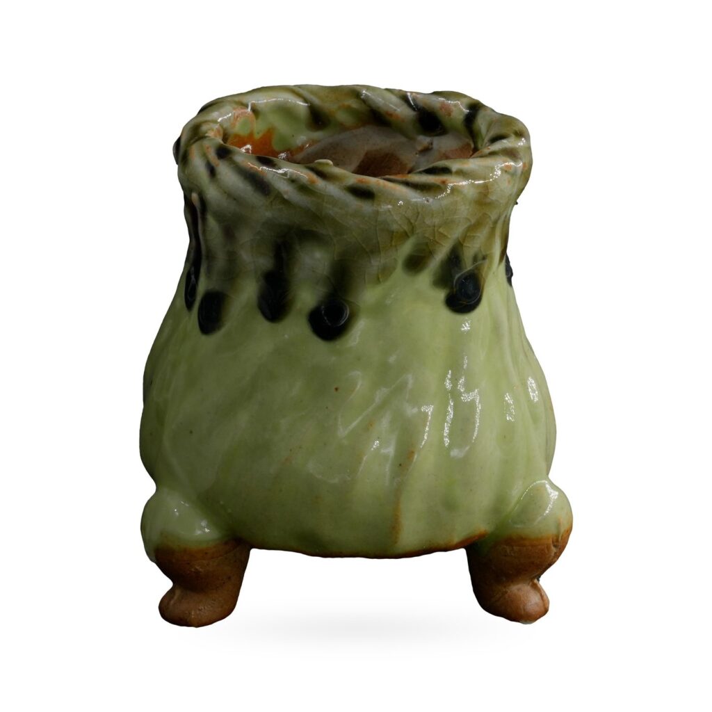 Footed pot in glossy pistachio green with a rope-twist rim and dark drips below the neck