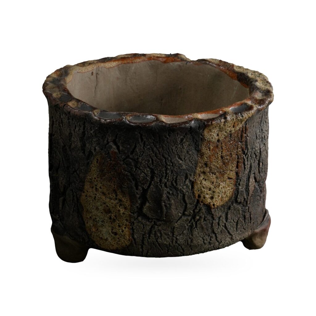 Round dark brown bark-texture footed pot with olive glaze drips and a scalloped rim