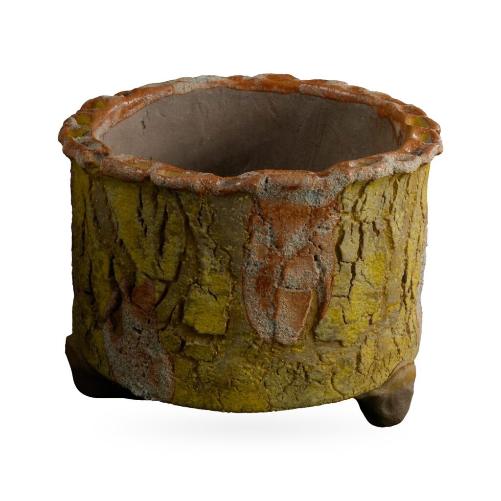 Mustard yellow bark-texture footed pot with rust-orange patches and a scalloped rim