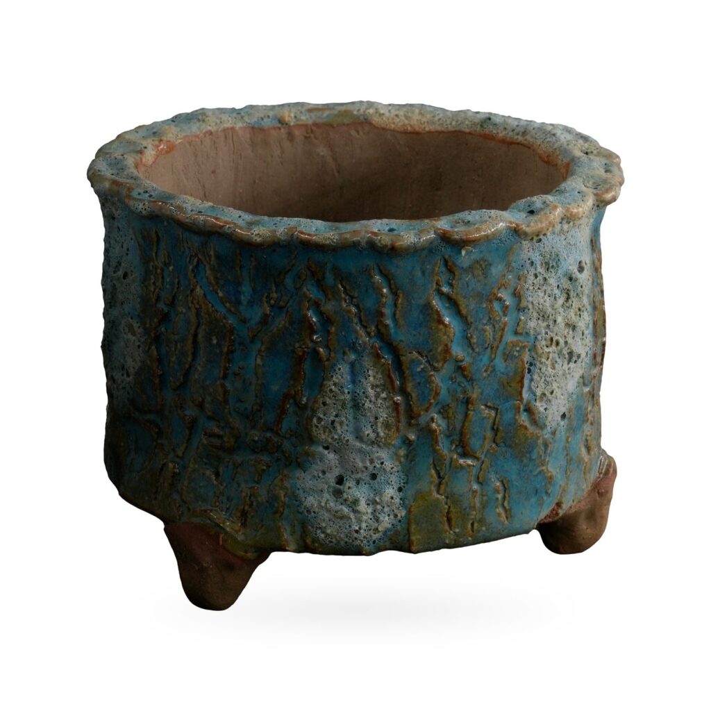 Round turquoise and teal bark-texture footed pot with pale lava-style glaze patches