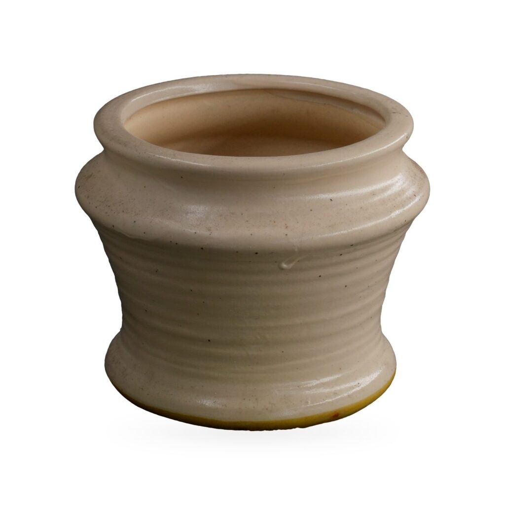 Small waisted cream glazed pot with fine dark speckles and horizontal ribbing
