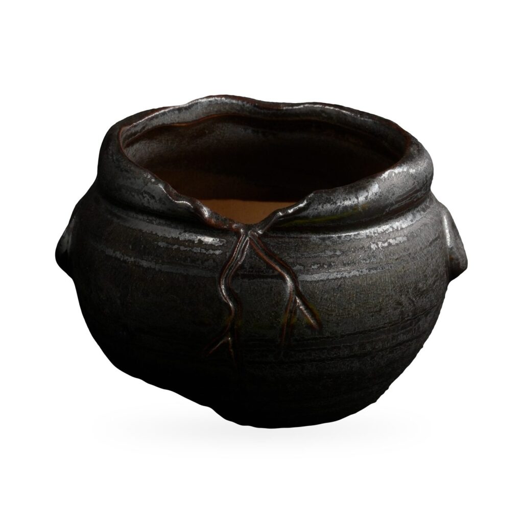 Round glossy black glazed pot with raised brown branch relief and side lug knobs
