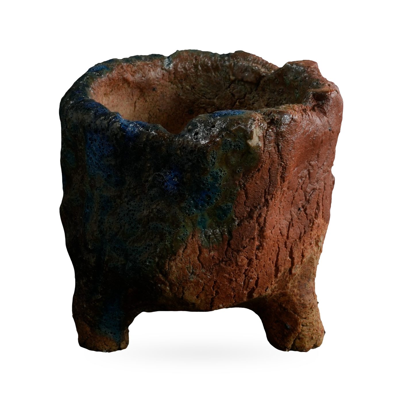 Rugged stump-like footed pot in red-brown clay with deep blue and teal glaze patches