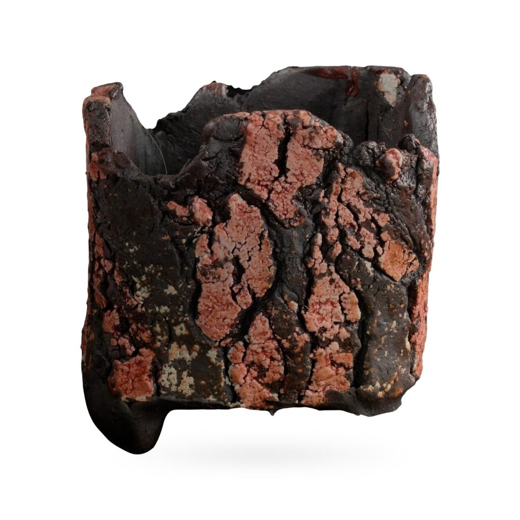 Square bark-texture pot in dark brown-black glaze with crackled salmon-pink patches and small feet
