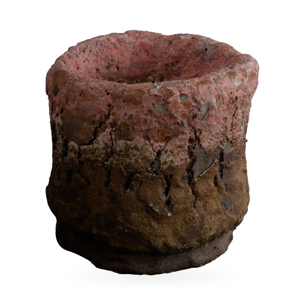 Rough stone-texture cylinder pot fading from dusty pink at the rim to ochre-brown at the base