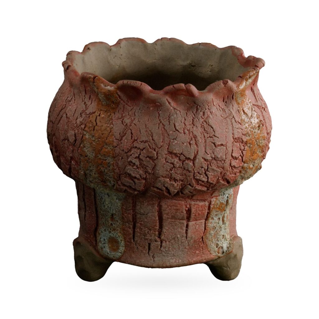 Terracotta-pink crackle-glaze footed pot with ochre streaks and a frilled scalloped rim
