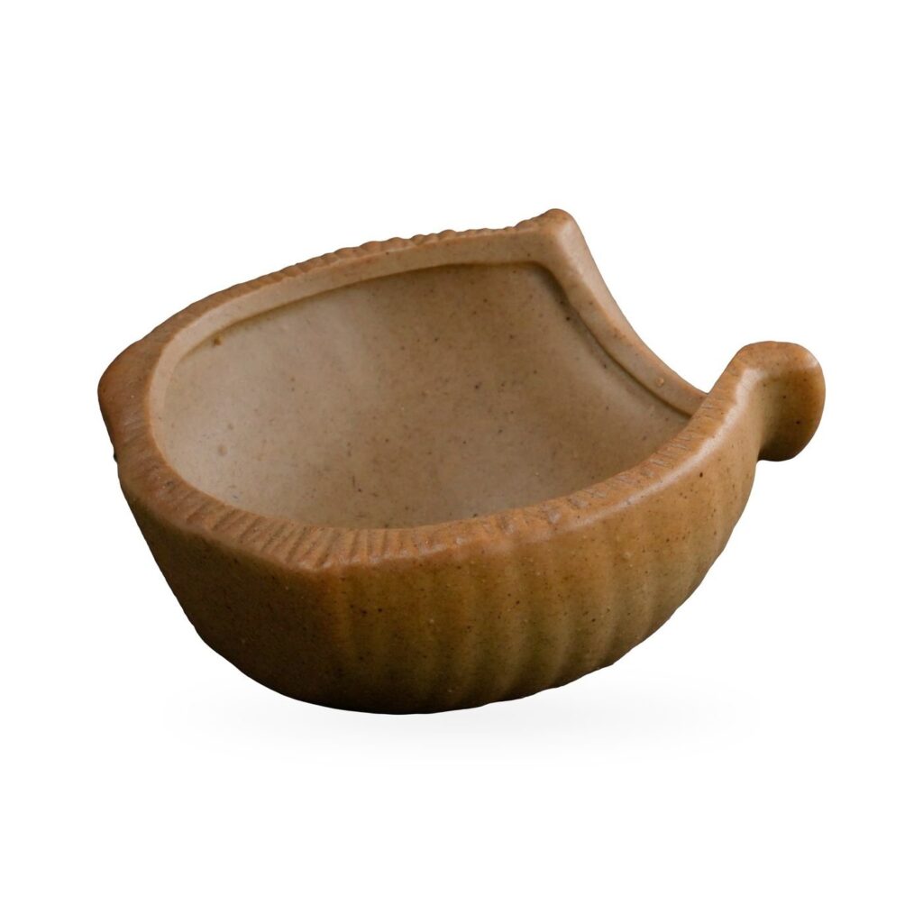 Shallow boat-shaped ribbed succulent pot in speckled sand beige with a curled handle at one end