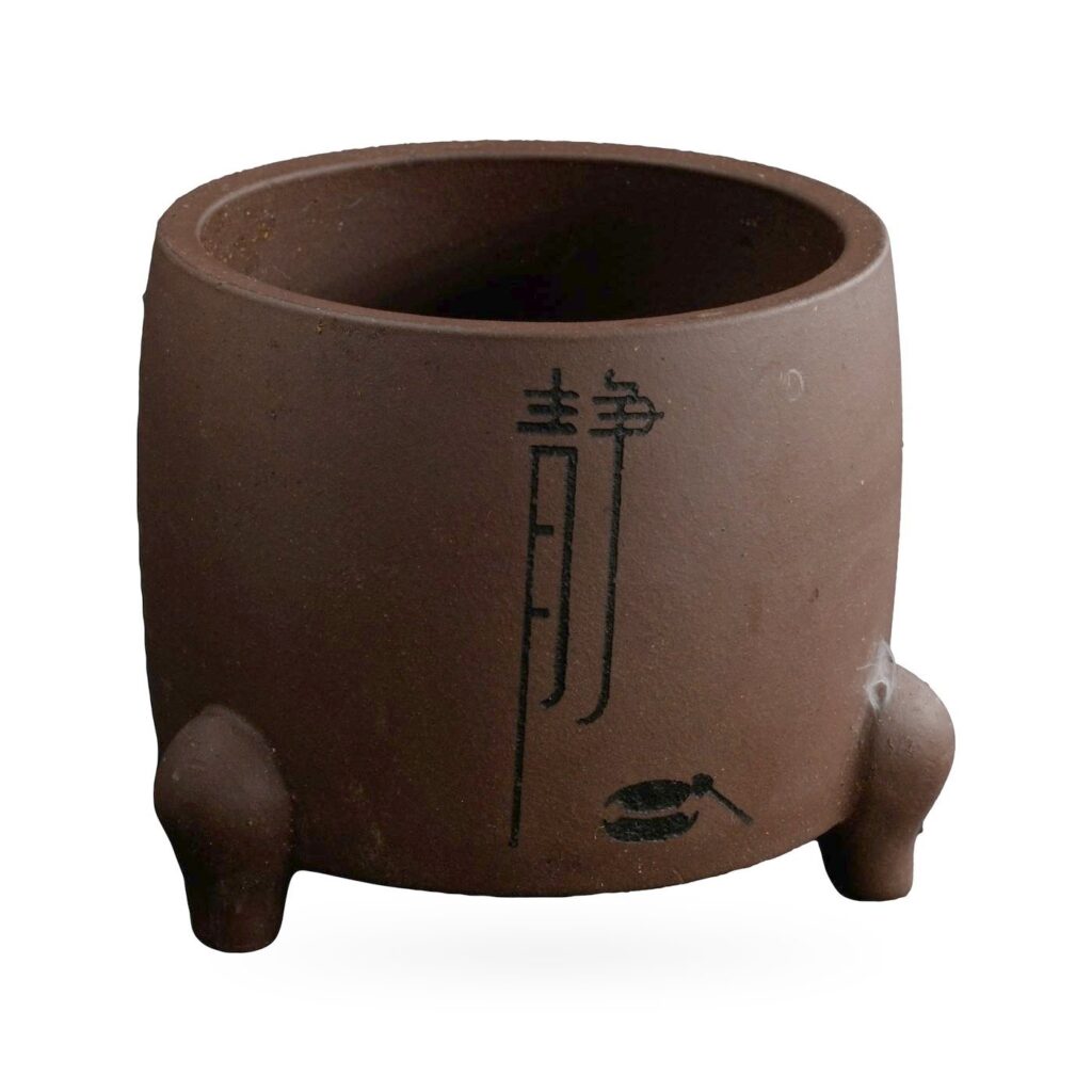 Drum-shaped matte purple-brown footed pot with a tall black calligraphy character