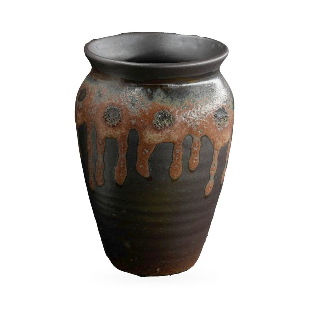 Tall black urn-shaped pot with rust-brown drip glaze and raised dotted medallions, 8.5×12cm