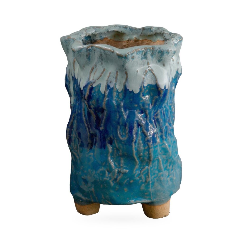 Tall cobalt and teal bark-textured footed pot with pale blue-white glaze dripping from a wavy rim