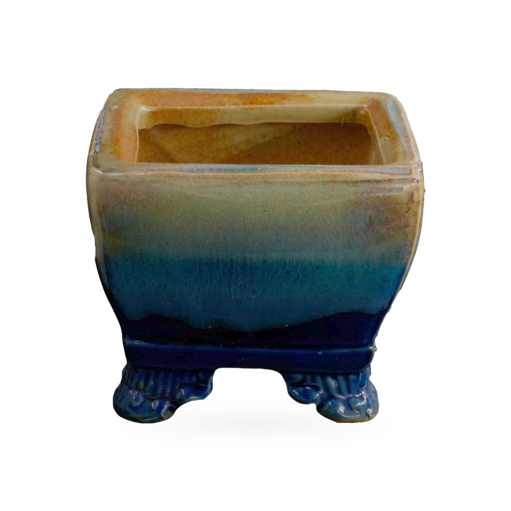 Square pot in glossy glaze fading from amber and sage at the rim to cobalt blue at the base and feet