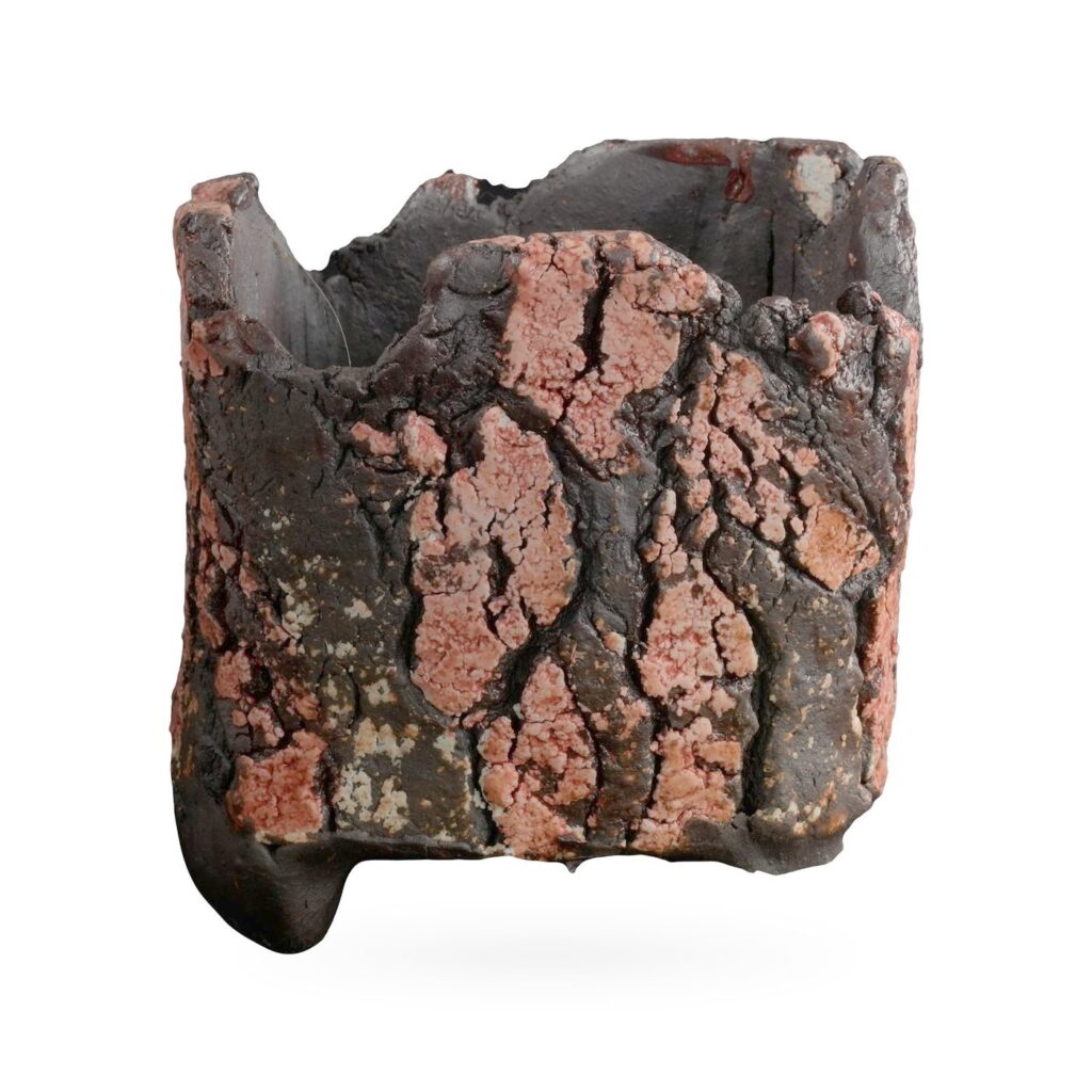 Square bark-texture pot in dark brown-black glaze with crackled salmon-pink patches and small feet