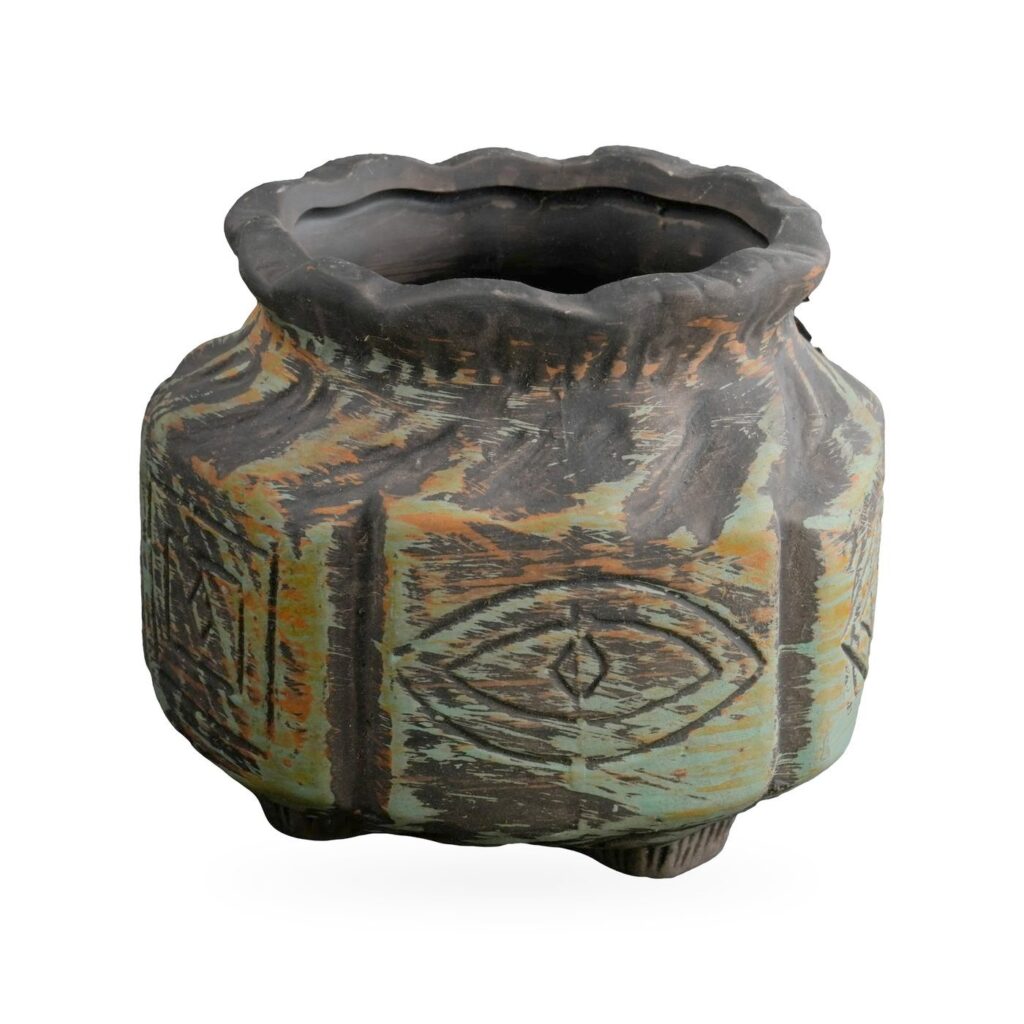 Rustic black and sage green pot with carved crescent moon, star and eye motifs and a wavy rim