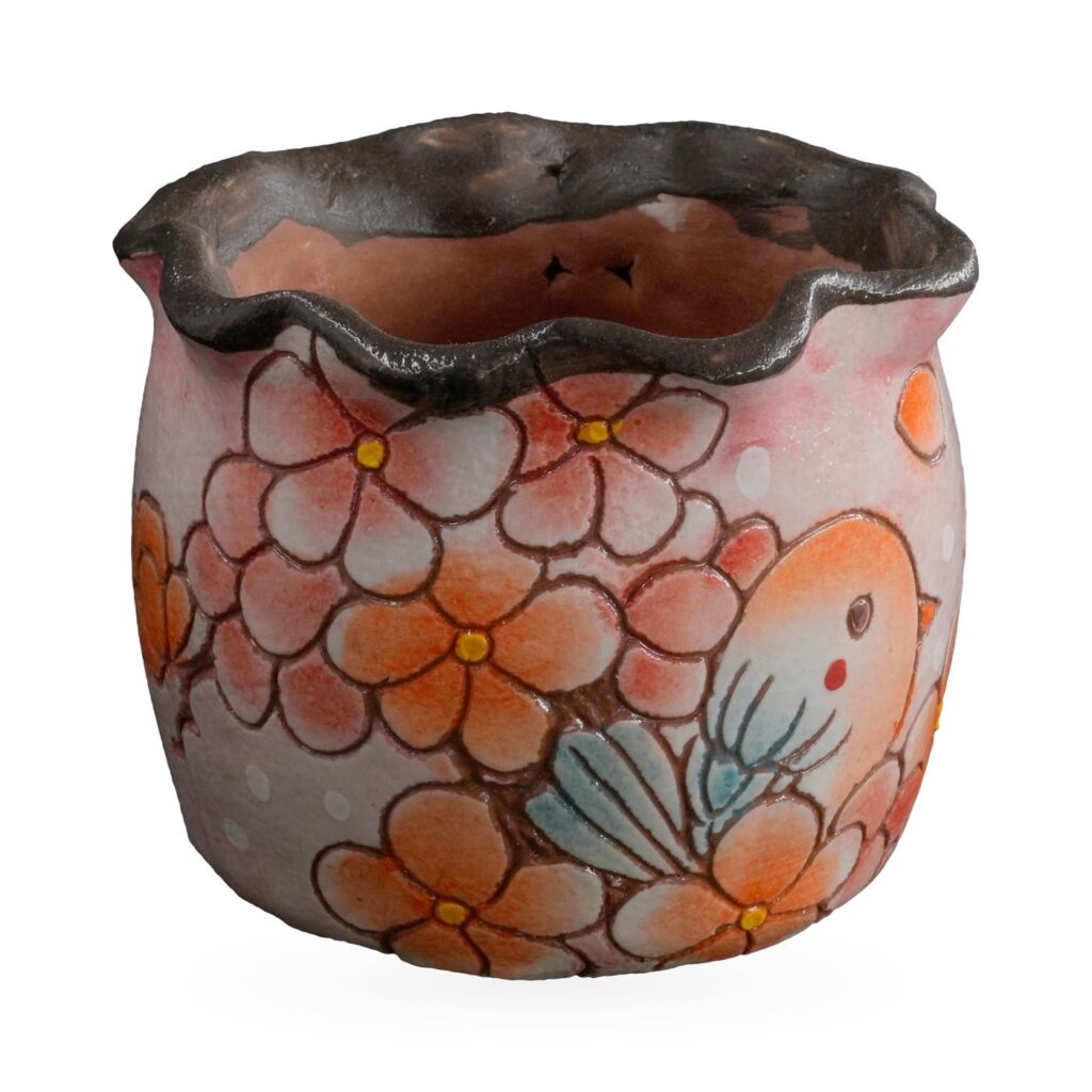 Pink painted succulent pot with orange blossoms, a small bird and a wavy dark rim
