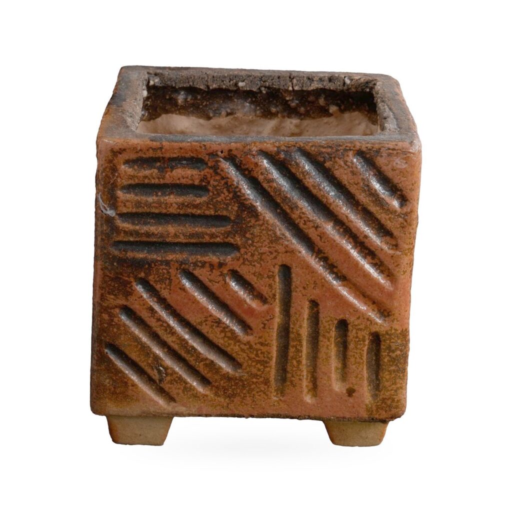 Speckled rust-orange square pot with carved line grooves, standing on small feet