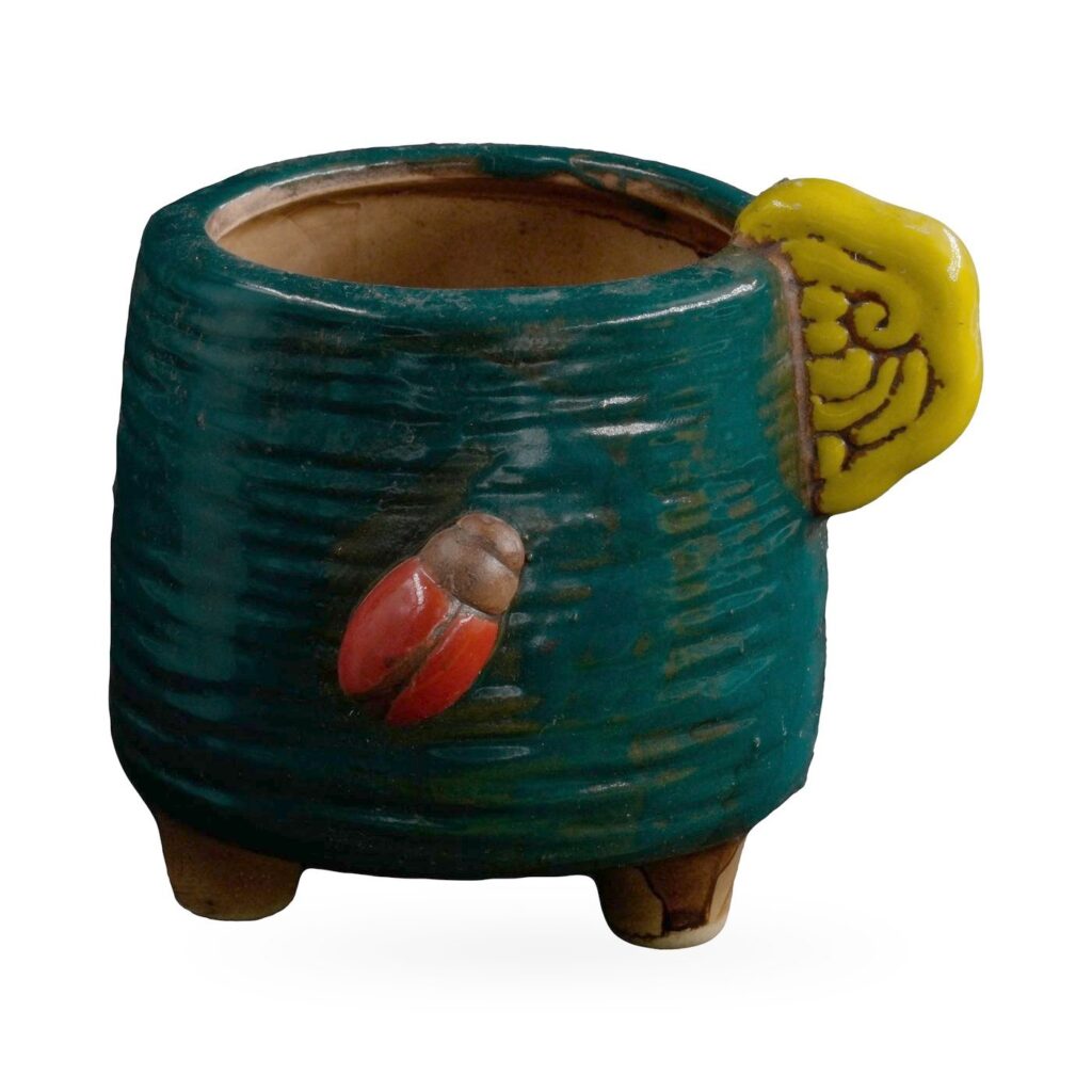 Dark green combed-texture footed pot with a yellow cloud-swirl tab and red ladybird