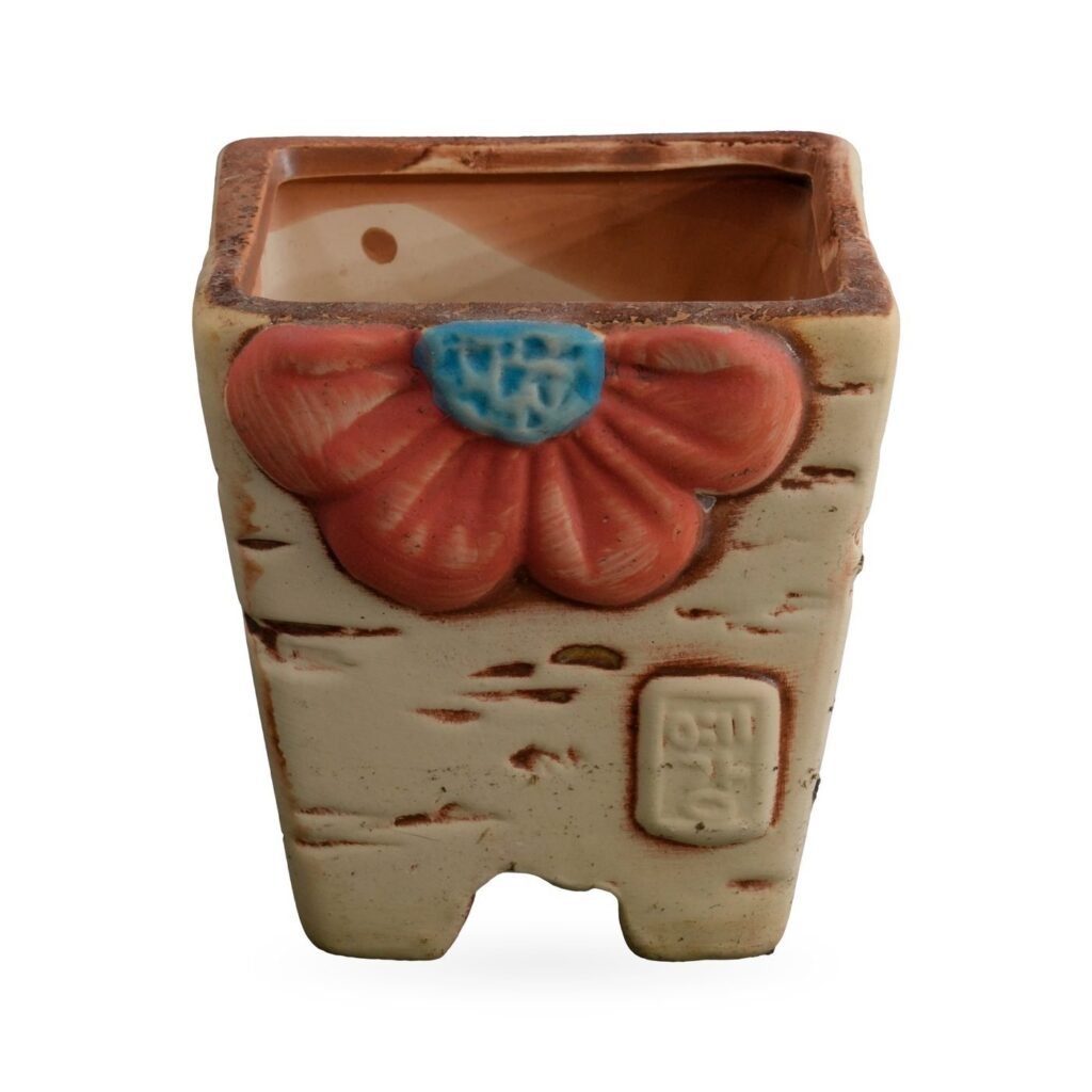 Cream tapered square succulent pot with raised orange-red flower, bark-style streaks and corner feet