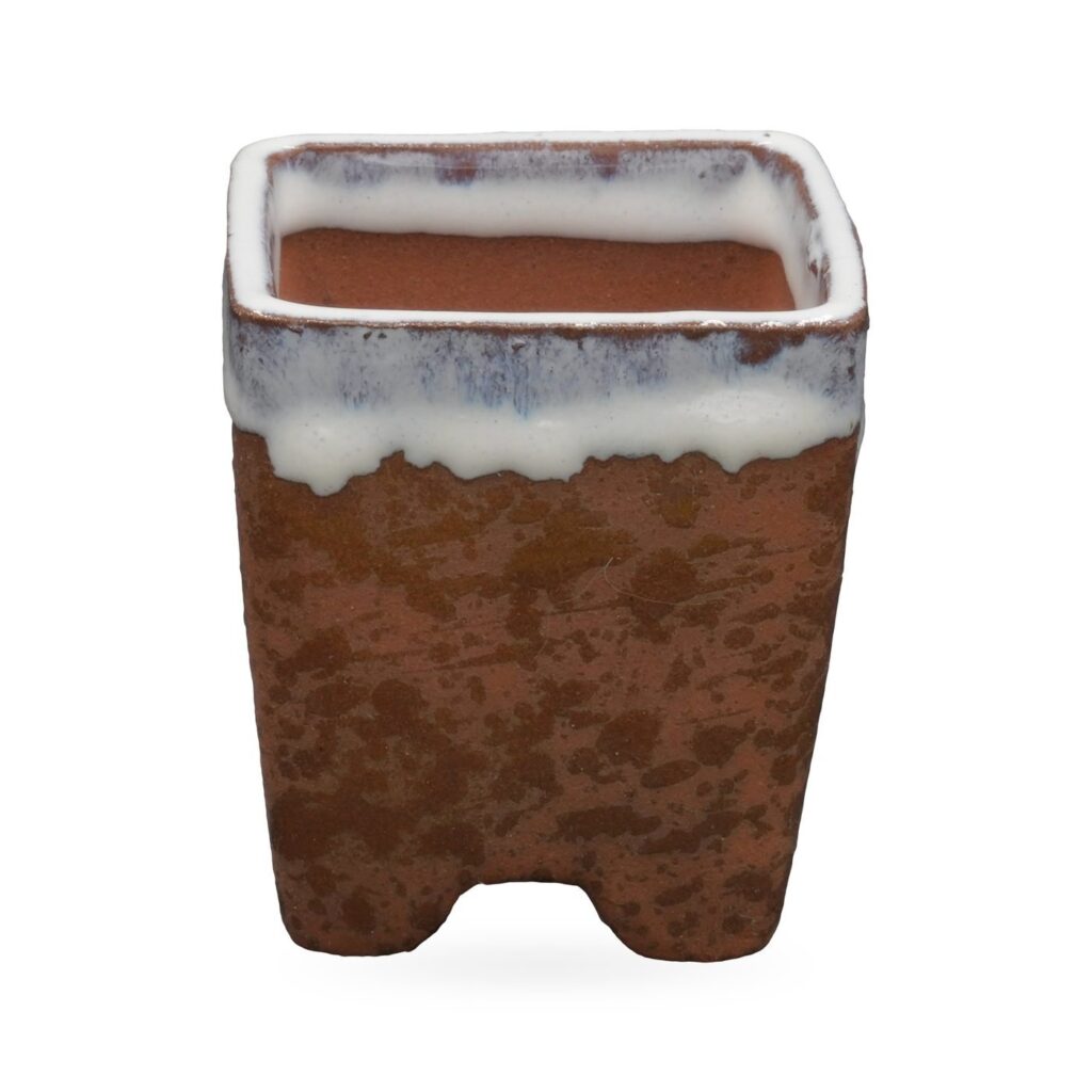 Speckled rust-brown square footed pot with glossy white drip glaze around the rim