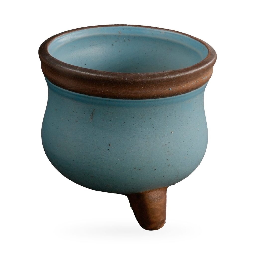 Small matte duck-egg blue cauldron-shaped succulent pot with brown rim on short brown feet