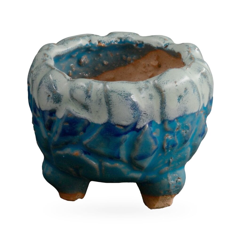 Footed textured pot in glossy blue with a pale white drip glaze around the rim