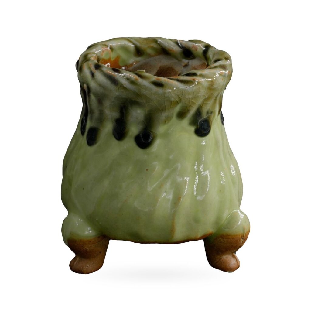 Footed pot in glossy pistachio green with a rope-twist rim and dark drips below the neck