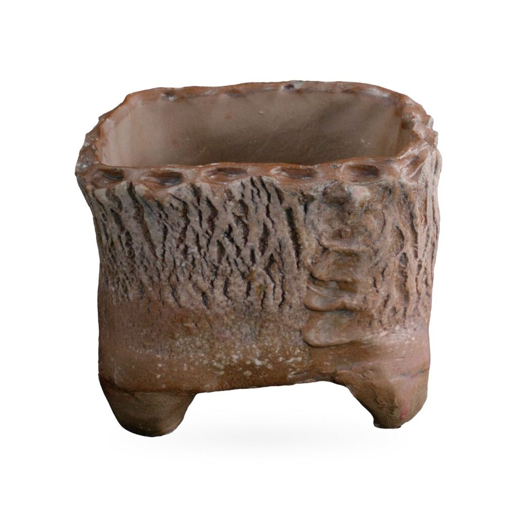 Rust-brown square footed pot with deep bark-like texture, ladder-like ridged corner and scalloped rim