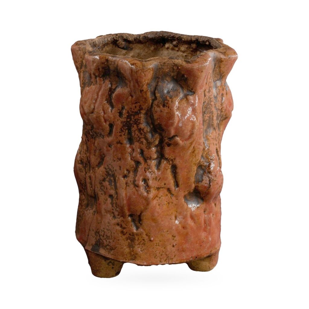 Tall rust-red bark-textured footed pot with dark brown tones and a wavy rim