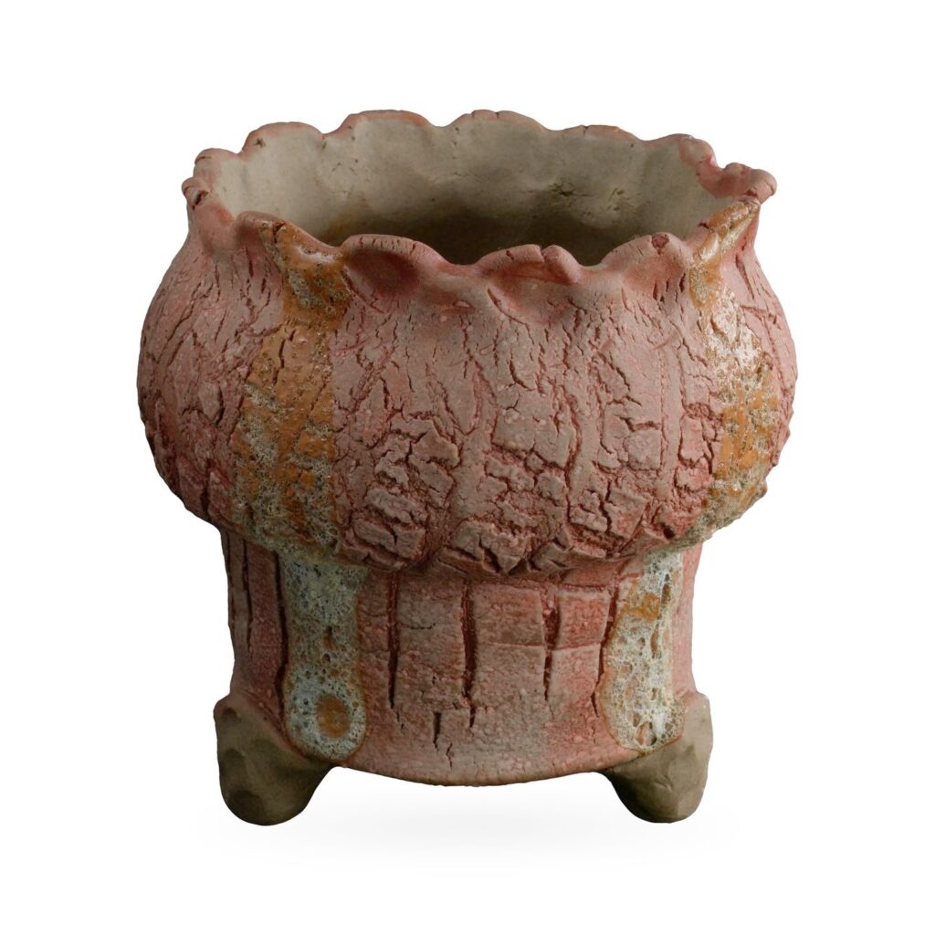 Terracotta-pink crackle-glaze footed pot with ochre streaks and a frilled scalloped rim