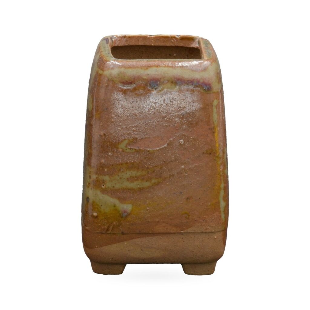 Tall tapered square pot in glossy rust-brown glaze with olive-green streaks, on small feet
