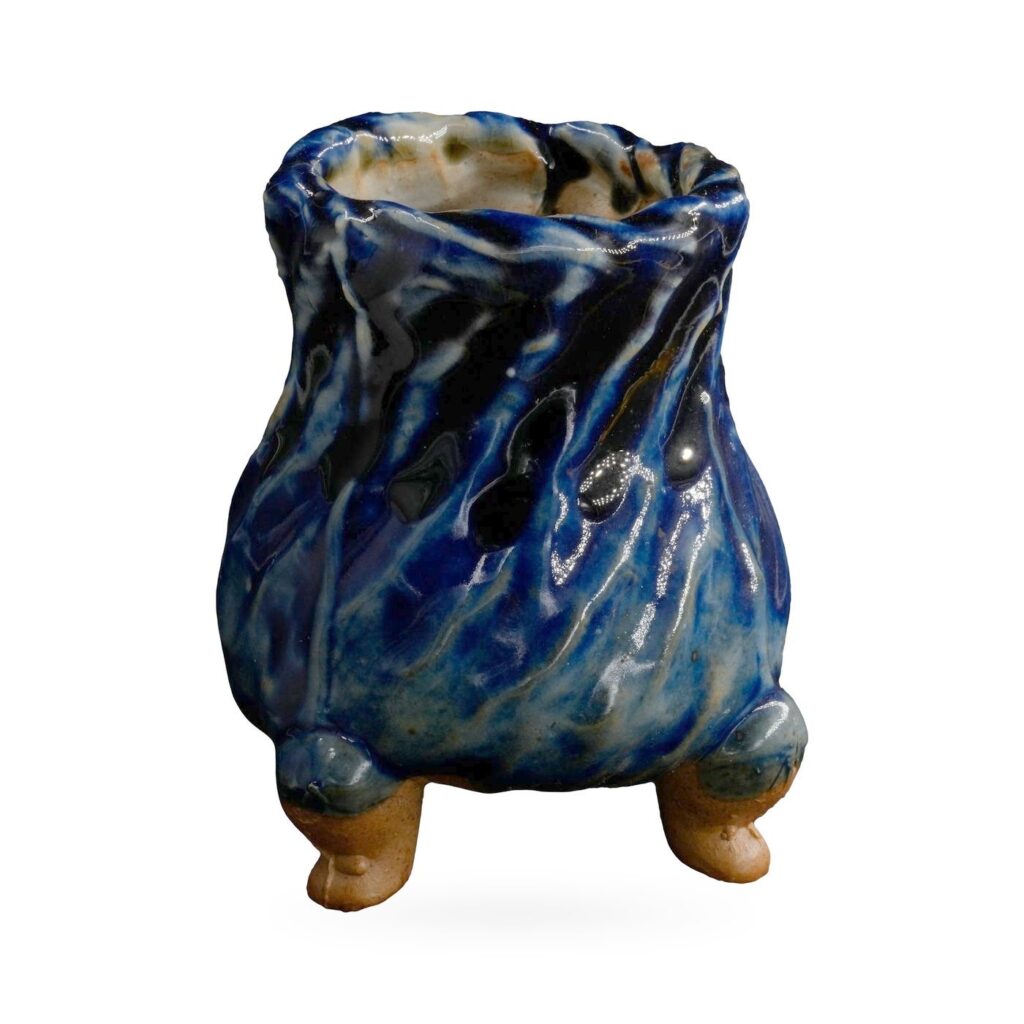 Tall footed pot with a twisted ridged body in glossy cobalt blue glaze with pale streaks