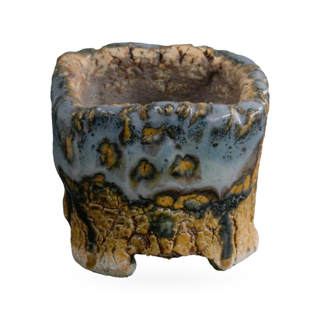 Mini square pot with glossy blue-grey glaze, amber spots and crackled ochre base on small feet